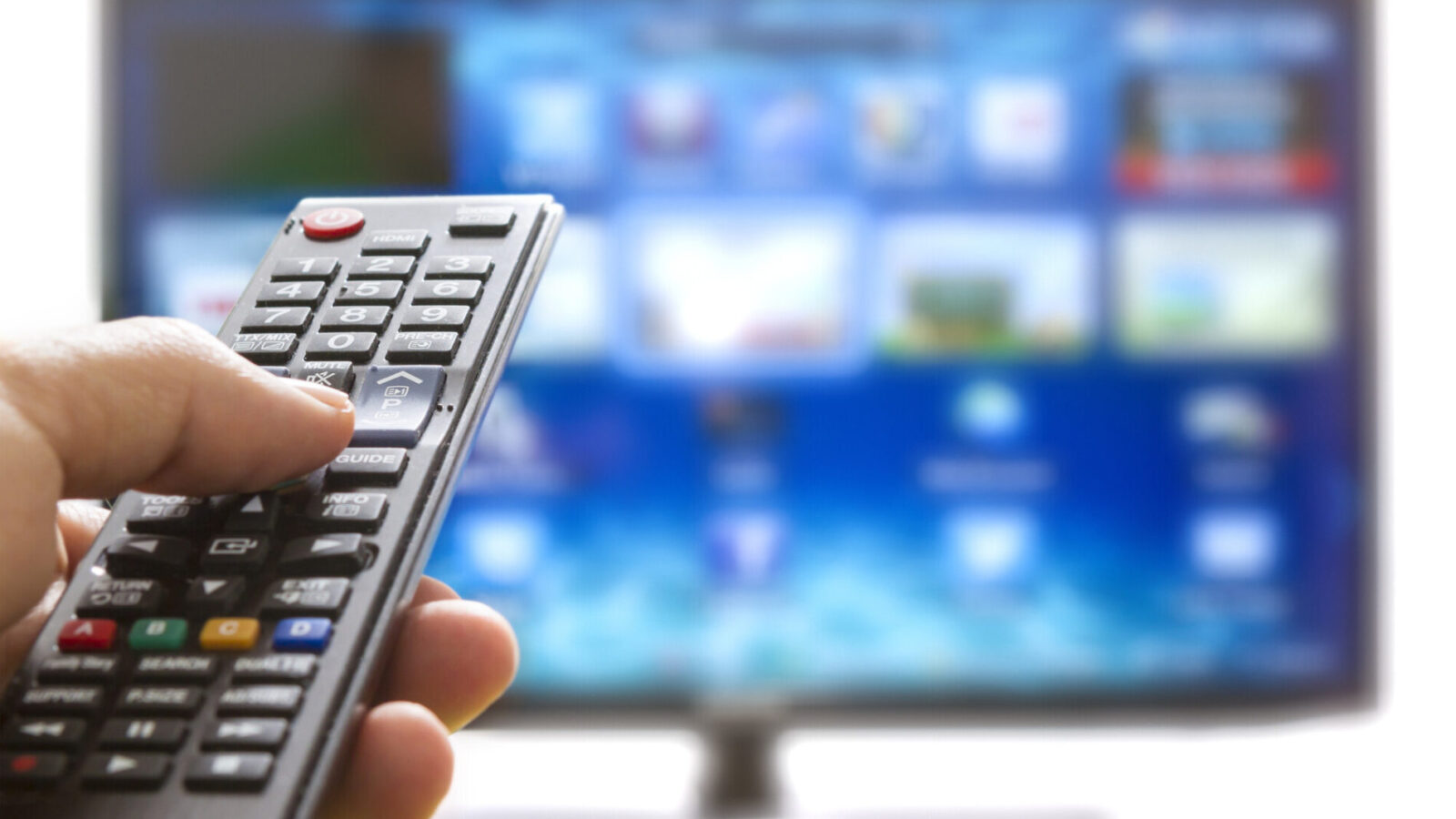 Television remote control changes channels thumb on the blue TV screen